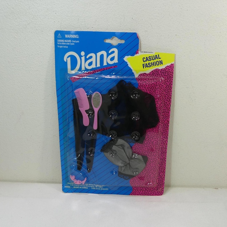 May include: A plastic package containing a black and gray outfit for a doll. The package also includes a pink comb and a pink hand mirror. The package is labeled "Diana Casual Fashion".