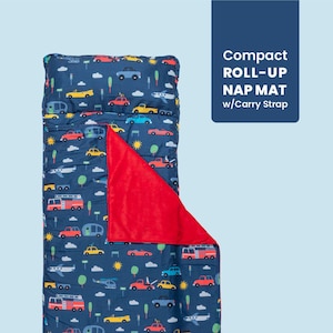 May include: A navy blue roll-up nap mat with a colorful vehicle pattern, including cars, planes, and buses. It features a red fleece blanket and a carry strap. The text on the image reads "Compact ROLL-UP NAP MAT w/Carry Strap."