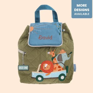 May include: An olive green quilted backpack featuring a blue flap with the name David embroidered in red. The front displays an embroidered safari scene with a lion, giraffe, and elephant in a light blue vehicle, plus a tag reading WILD ONE.