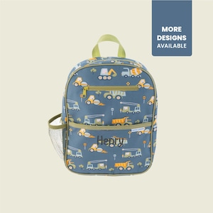 May include: Blue backpack with a construction vehicle pattern, featuring a top handle, side mesh pocket, and a front pocket. The name "Henry" is printed on the front. The text "MORE DESIGNS AVAILABLE" is on a blue rectangle.