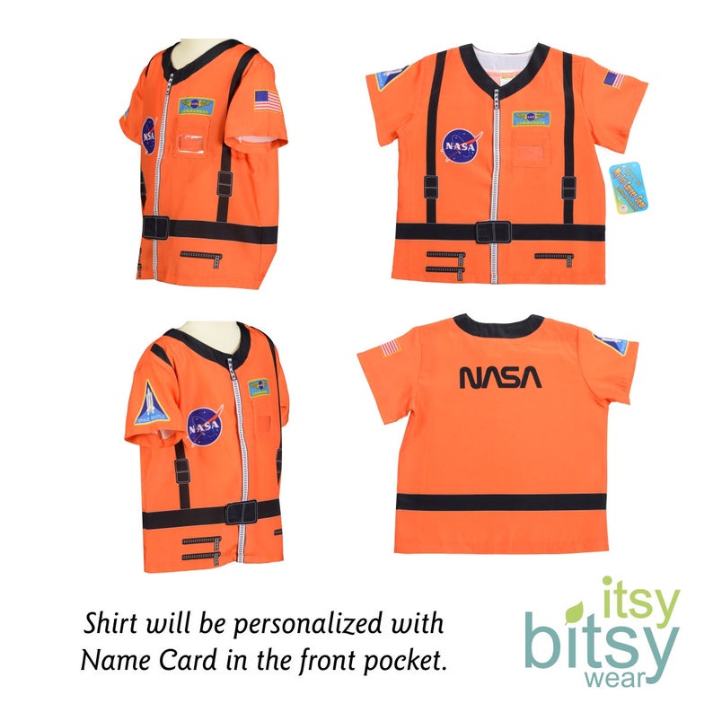 Puede incluir: Camiseta naranja de manga corta con parches negros de la NASA y una cremallera. La camiseta tiene un cintur&oacute;n negro y un bolsillo en la parte delantera. La camiseta est&aacute; sobre un fondo blanco. El texto "itsy bitsy wear" est&aacute; en la esquina inferior derecha de la imagen.