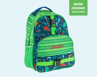 May include: Green and blue dinosaur-themed backpack with a green and white striped pocket and a green adjustable strap. The backpack has the name Landon embroidered on the front.