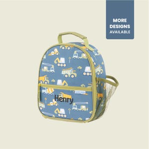 May include: A blue lunch bag with a construction vehicle pattern, featuring trucks and excavators. The bag has a green handle, a side mesh pocket, and the name "Henry" printed on the front. The text "MORE DESIGNS AVAILABLE" is also visible.