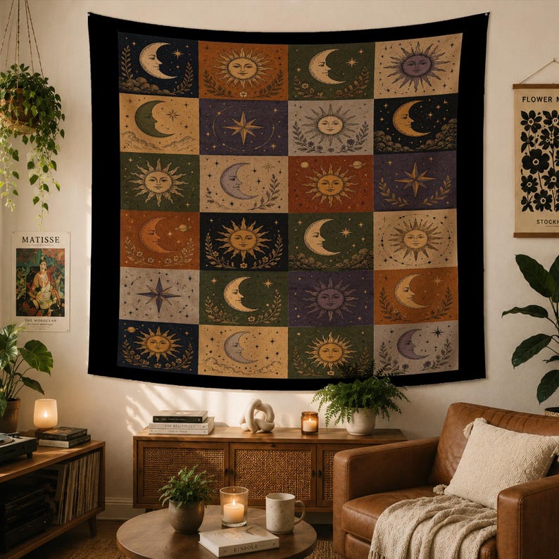 May include: A large tapestry with a black border, featuring a grid of celestial designs. Each square showcases a sun, moon, or star in warm, earthy tones. The tapestry is hung on a wall, adding a bohemian touch to the room.