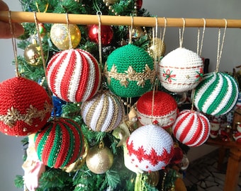 May include: A collection of handmade crocheted Christmas ornaments in various colors and patterns, including red, white, green, and gold. The ornaments are hanging from a wooden rod.