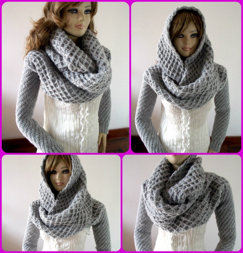 May include: Gray knitted cowl neck scarf with a hood. The scarf is made of a chunky yarn and has a waffle stitch pattern.