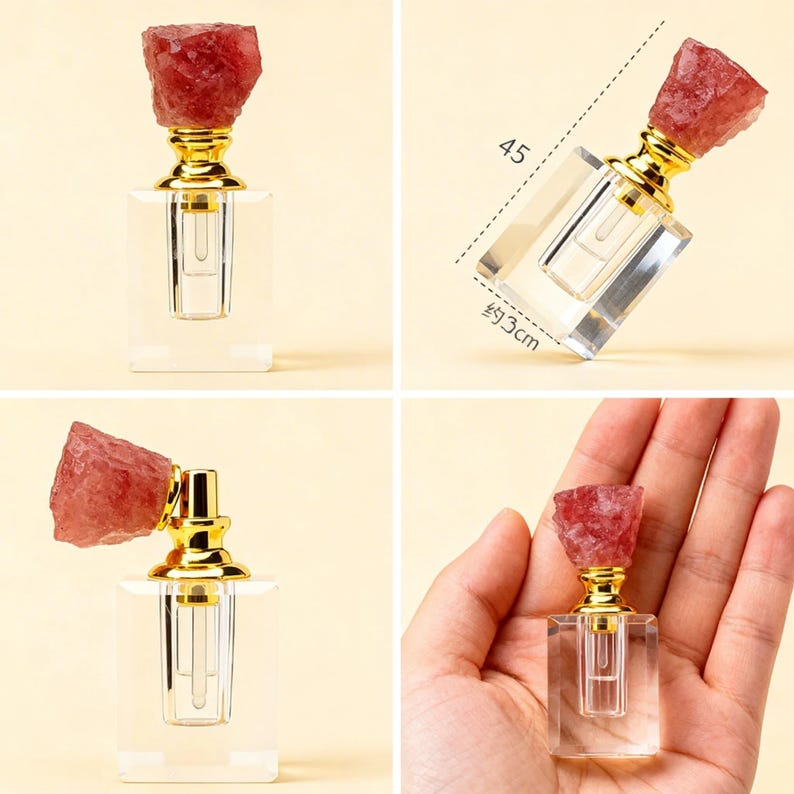 May include: A clear, rectangular perfume bottle with a gold-colored neck and a rough, red-pink crystal stopper. The bottle is approximately 1.2 inches wide and 1.8 inches tall. The design is elegant and minimalist.