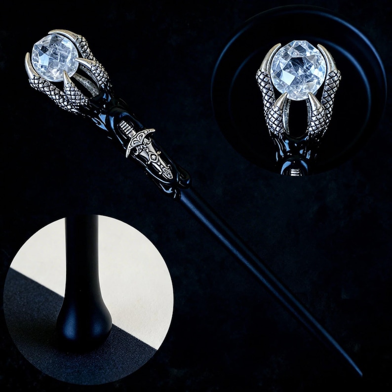Peut inclure: Une baguette noire avec un design de griffes argent&eacute;es tenant un cristal clair. La baguette pr&eacute;sente des d&eacute;tails complexes sur le manche et un embl&egrave;me argent&eacute; d&eacute;coratif. Le cristal est facett&eacute;, refl&eacute;tant la lumi&egrave;re. Objet sur le th&egrave;me de la fantaisie.