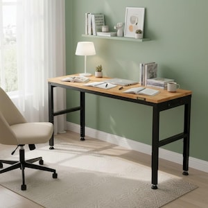 May include: A home office setup featuring a light wood desk with black metal legs, a beige office chair, and a white lamp. The desk is set against a green wall, with a window and sheer curtains to the left. Books and a laptop are on the desk.
