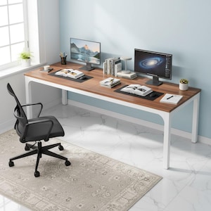 May include: A long, brown and white desk with two computer monitors, books, and office supplies. A black office chair sits in front of the desk. A patterned rug is on the floor.
