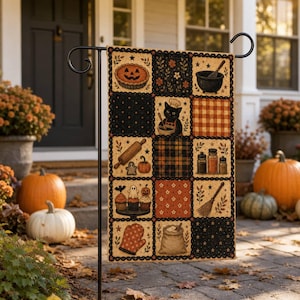 May include: A rectangular garden flag featuring a patchwork design with Halloween baking motifs. The grid displays a pumpkin pie, a black cat wearing a chef hat, a rolling pin, cupcakes, a broom, an oven mitt, and a sack of flour in orange and black.