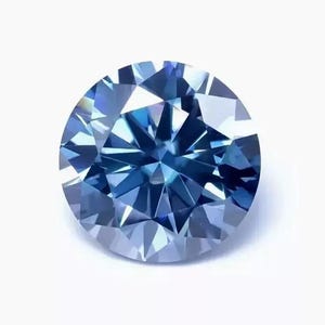 May include: A round-cut gemstone with a deep blue color and a faceted surface. The stone displays a brilliant sparkle with geometric light reflections across its circular shape, showcasing a clear, transparent quality and a polished finish.