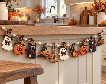 Może przedstawiać: Girlanda na Halloween z drewnianymi wycinankami przedstawiającymi duchy, dynie, czarne koty, kapelusze czarownic, miotłę i półksiężyc, nawleczone na naturalny sznurek z białymi drewnianymi koralikami, utrzymana w jesiennej kolorystyce.