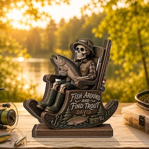 May include: A decorative wooden rocking chair figurine featuring a skeleton wearing a fishing hat, vest, and boots, holding a large trout. The base is engraved with the text "Fish Around and Find Trout" and the name "David" above a trout graphic.