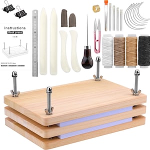 May include: A wooden book press with metal hardware, accompanied by various bookbinding tools. The press is made of light-colored wood and includes a set of instructions. Additional tools include needles, thread, scissors, and other accessories. The press measures 30" x 19.5" x 1.8".
