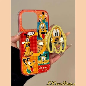 May include: A clear phone case with a colourful Pluto design. The case features Pluto in various poses, with the words "I'm ok" and "Happy Pluto" on the case. A matching Pluto phone grip is also visible.