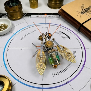 May include: A mechanical insect sculpture constructed from brass and silver-toned metal gears, cogs, and springs. The body features a translucent green cylindrical component, while the wings are crafted from intricate gold-toned metal filigree.