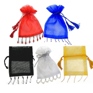 May include: Five small drawstring bags made of sheer fabric with beaded trim and tassels. The bags are in red, blue, black, white, and gold.
