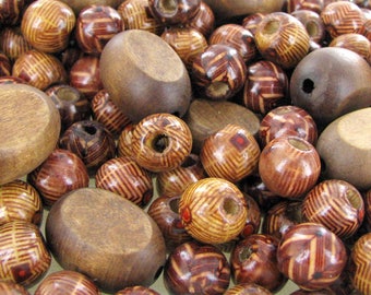 May include: A collection of wooden beads in various shades of brown with intricate patterns. The beads are round and oval shaped, with some having a smooth finish and others having a textured surface.