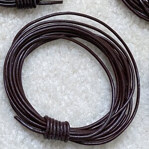 May include: A coil of dark brown leather cord. The cord is approximately 1/8 inch thick and is ideal for crafting projects.