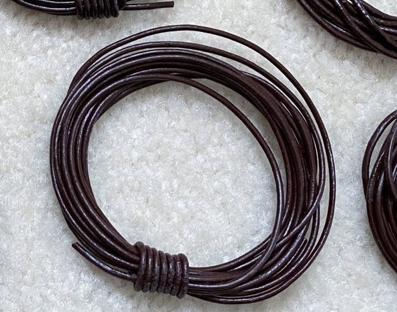 May include: A coil of dark brown leather cord. The cord is approximately 1/8 inch thick and is ideal for crafting projects.