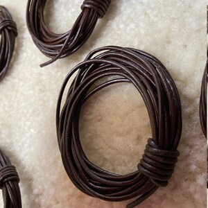 May include: A close-up of a spool of brown leather cord. The cord is wound tightly and is ready to be used for crafting projects.