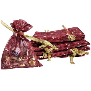 May include: A stack of 10 burgundy organza gift bags with gold stars and gold ribbon ties. The bags are made of sheer fabric and are perfect for small gifts or favors.