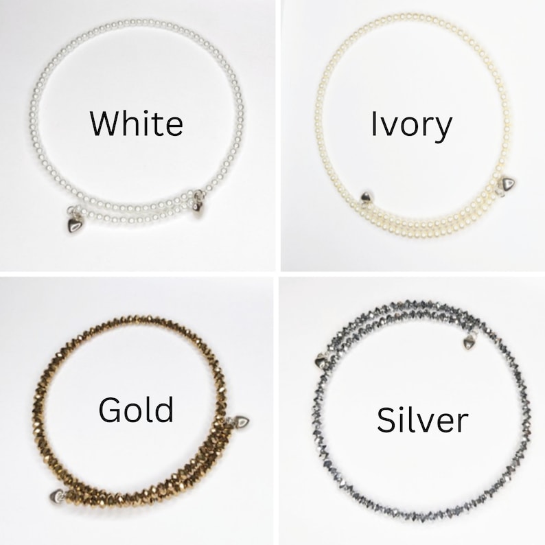 K&ouml;nnte beinhalten: Vier Armb&auml;nder mit Herzanh&auml;ngern. Die Armb&auml;nder sind aus wei&szlig;en Perlen, elfenbeinfarbenen Perlen, goldenen Perlen und silbernen Perlen gefertigt. Die Armb&auml;nder sind mit "Wei&szlig;", "Elfenbein", "Gold" und "Silber" beschriftet.