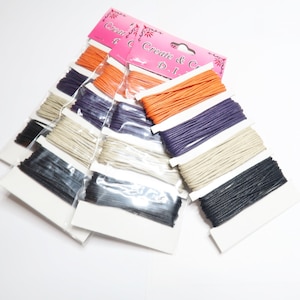 May include: A package of six spools of waxed cotton cord in various colors, including black, white, orange, and purple. The spools are labeled "Create & Craft D.I.Y."