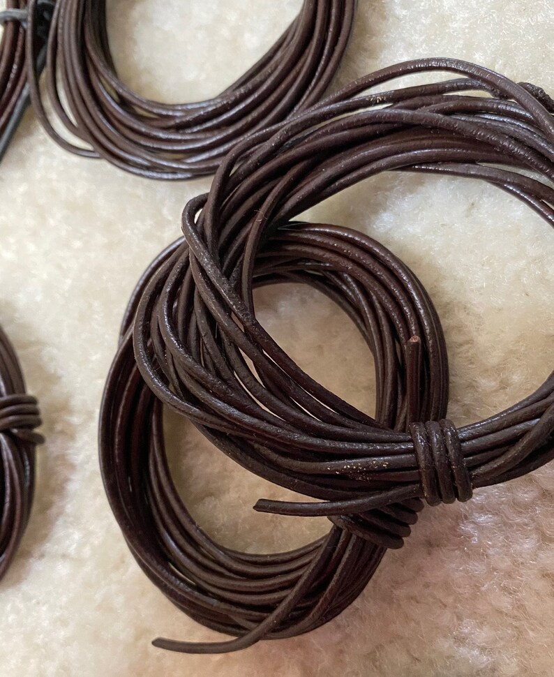 May include: A close-up of a spool of brown leather cord. The cord is wound tightly and is ready to be used for crafting projects.