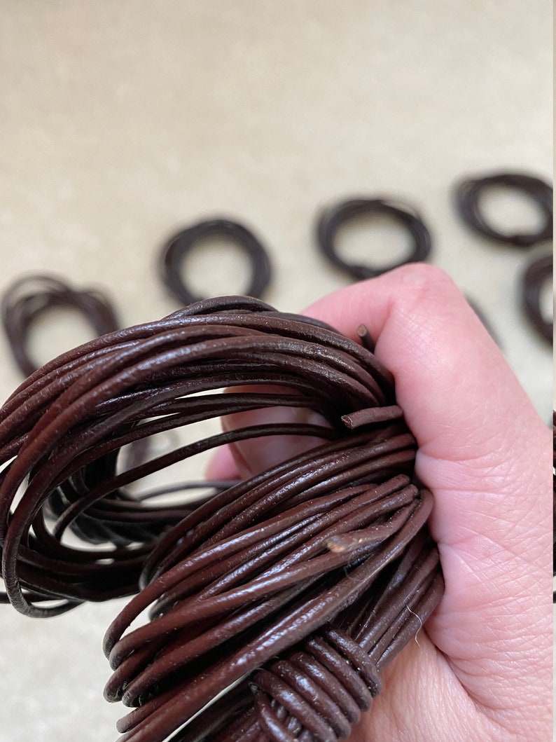 May include: A close-up of a bundle of brown leather cord. The cord is soft and supple, and it is perfect for crafting jewelry, bracelets, and other projects.