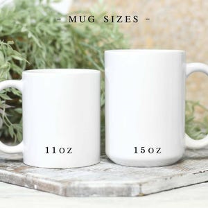 May include: Two white ceramic mugs with handles, displayed side by side. The smaller mug is labeled 11oz and the larger mug is labeled 15oz. The text MUG SIZES is centered above the mugs. The mugs have a smooth, glossy finish and a cylindrical shape.