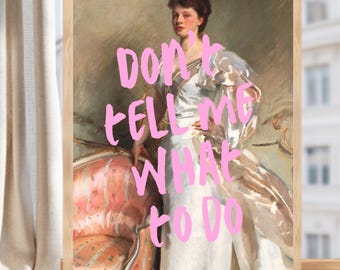 May include: A framed art print featuring a classical oil painting of a person in a white gown standing beside a pink upholstered chair. Overlaid on the image in bold, hand-lettered pink text are the words, "DON'T TELL ME WHAT TO DO."