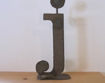 Lowercase metal letter "j" on stand