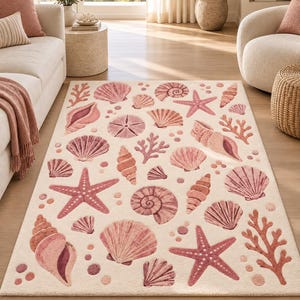 Könnte beinhalten: Ein rechteckiger Teppich mit cremefarbenem Hintergrund und einem wiederkehrenden Muster aus verschiedenen Muscheln, Seesternen und Korallenzweigen in Rosa-, Korallen- und Mauvetönen. Das Design zeigt diverse Muschelformen und Texturen.