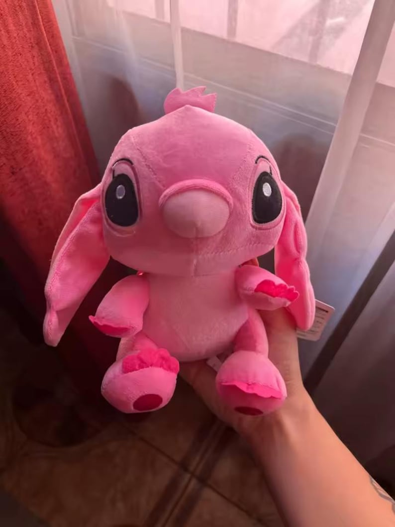 Puede incluir: Un peluche rosa de un personaje de dibujos animados con grandes ojos negros, orejas largas y una peque&ntilde;a antena. El juguete tiene una textura suave y difusa.