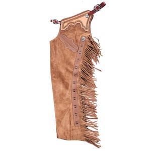 May include: A tan suede leather chap featuring a long fringe along the side, a smooth light tan leather yoke with decorative stitching, and dark brown leather straps with metal buckles at the top for secure fastening and adjustment.