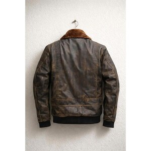 Men wearing distressed brown leather bomber jacket with fur collar and vintage aviator style.