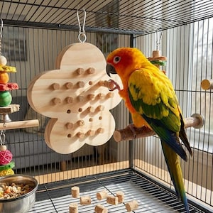 May include: A Sun Conure parrot perched on a wooden perch inside a cage, interacting with a wooden flower-shaped toy. The bird has vibrant yellow, orange, and green plumage. The toy has cork pieces inserted into the holes. Additional bird toys and a food bowl are also visible.