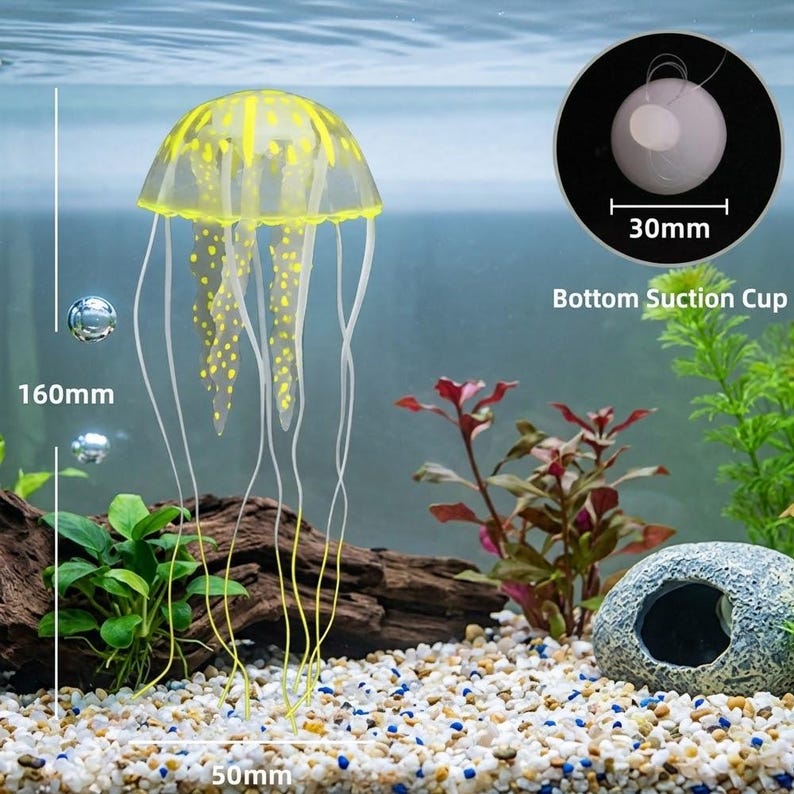 Pu&ograve; includere: Una medusa artificiale gialla e trasparente, alta 16 cm e larga 5 cm, con lunghi tentacoli fluenti. La medusa presenta macchie e strisce gialle. &Egrave; inclusa una ventosa di 30 mm di diametro. Il testo "Bottom Suction Cup" &egrave; visibile.