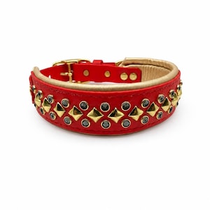 May include: A red collar featuring a gold-toned buckle and hardware. The exterior is decorated with a repeating pattern of gold-toned pyramid studs and small, dark circular crystals. The interior lining is a light tan color with visible stitching.