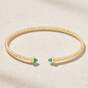May include: A gold-toned cuff bracelet featuring a twisted rope-style band. The open-ended design terminates at each side with a smooth, polished gold-toned cap holding a small, rounded, vibrant green stone accent at the center of each tip.