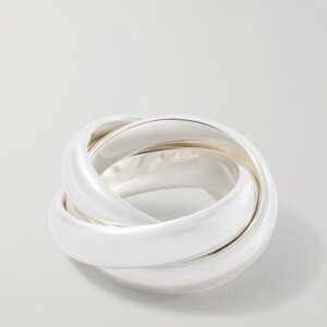 May include: A polished silver ring composed of three interlocking bands that create a continuous, rounded shape. The metal surface is smooth and reflective, showing a bright metallic sheen throughout the interconnected circular structure.