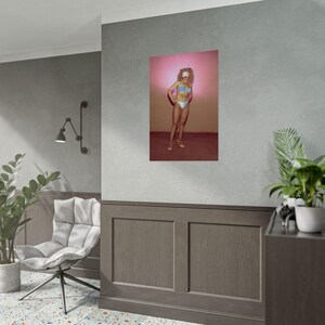 a poster of a woman with a colorful, stylized design on a gray wall.