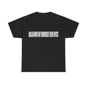 May include: Black t-shirt with the text "BAND OF BROTHERS" in distressed white lettering across the chest. The shirt has short sleeves and a crew neck.