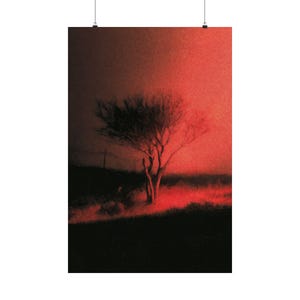 May include: A poster print featuring a solitary tree silhouetted against a vibrant red sky. The artwork evokes a sense of mystery and drama, with the tree's branches reaching upwards. The landscape is rendered in dark tones, creating a striking contrast.