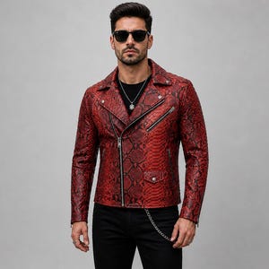 May include: A red leather jacket with a snakeskin pattern. The jacket has a zipper closure, two front pockets, and a silver chain detail. The model is wearing black pants and sunglasses.