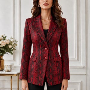 Könnte beinhalten: Ein roter und schwarzer Blazer mit Schlangenmuster, mit fallendem Revers, zwei Vordertaschen und zwei Knöpfen. Der Blazer ist mit einer taillierten Silhouette geschnitten. Das Model trägt eine schwarze Hose und ein schwarzes Oberteil.