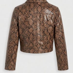 Peut inclure: Veste en similicuir marron avec un motif peau de serpent. La veste a un col classique, des manches longues et une coupe courte. Le dos de la veste est visible, mettant en valeur l'imprim&eacute; et le design d&eacute;taill&eacute;s.