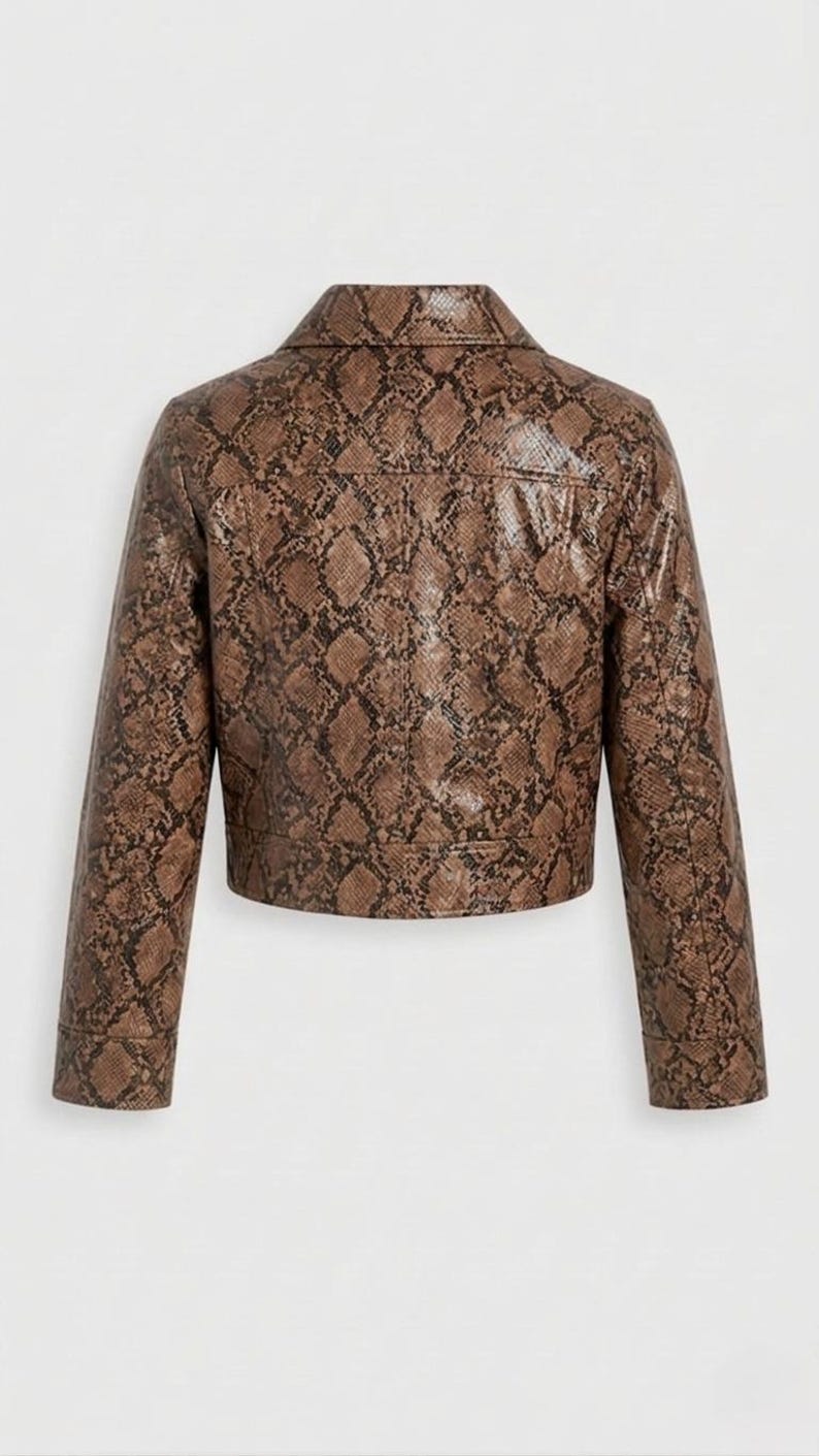 Peut inclure: Veste en similicuir marron avec un motif peau de serpent. La veste a un col classique, des manches longues et une coupe courte. Le dos de la veste est visible, mettant en valeur l'imprim&eacute; et le design d&eacute;taill&eacute;s.